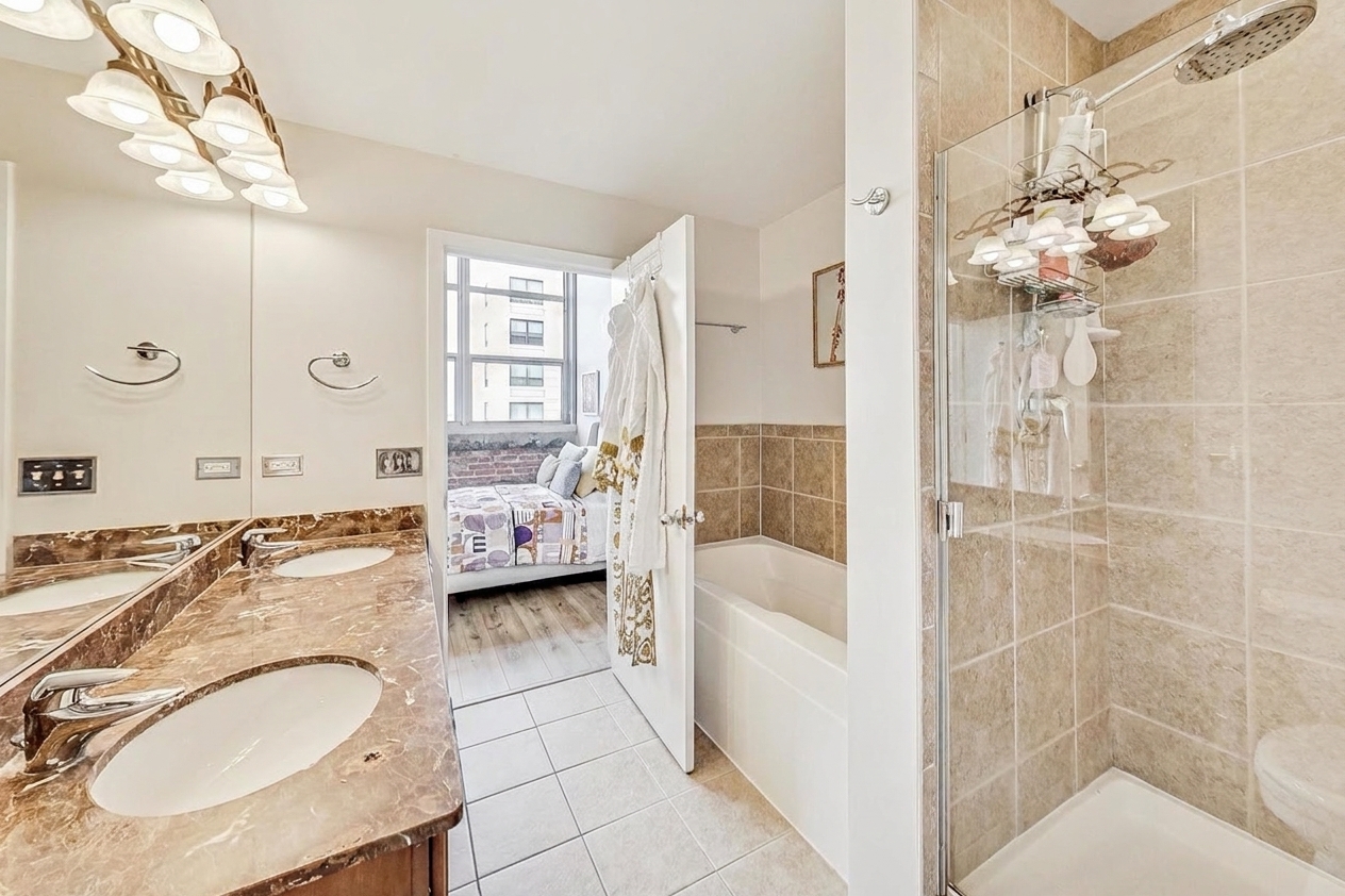 The first bath with double vanity, bathtub, and shower