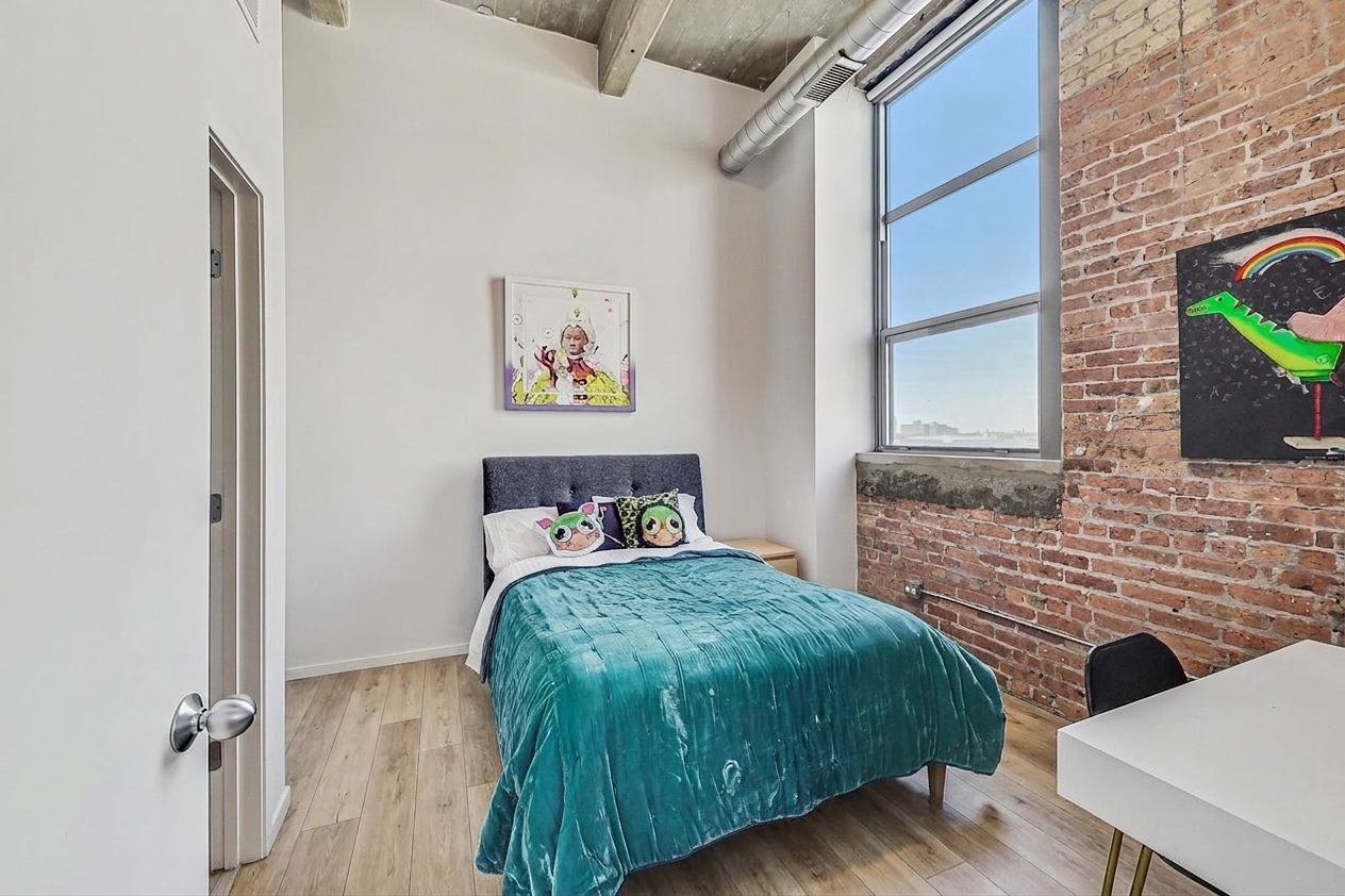 Bedroom two with exposed brick and the new wide plank floors